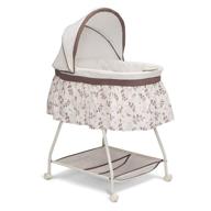 🌿 delta children deluxe sweet beginnings bedside bassinet - portable crib with lights, sounds, and falling leaves logo