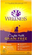 🐶 wellness complete health dry puppy food, chicken recipe, natural, made in the usa, meat by-products-free, filler-free, artificial flavors-free, preservative-free, with added vitamins, minerals, and taurine. logo