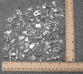 img 2 attached to 🎃 Yansanido 100pcs Mixed Skulls Masks Halloween Charms Pendants - Craft Supplies Charms for Jewelry Making and Crafting - Antique Silver Halloween Collection - DIY Charms (100 pcs Mixed Skull Silver)