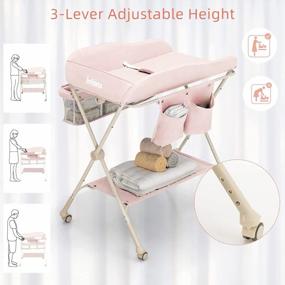 img 2 attached to Портативный складной пеленальный столик для младенцев с регулируемой высотой, ремнем безопасности, стеллажом для сушки и хранения, мобильной подставкой-органайзером на колесах для новорожденных - розовый